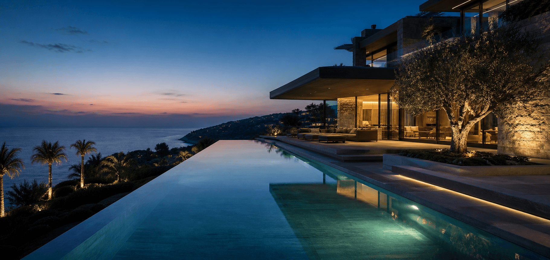 Coastal home with an illuminated infinity pool at dusk